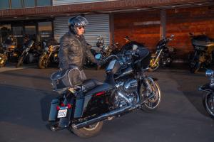 Photo of Daytrip on Black motorcycle, man standing behind with helmet