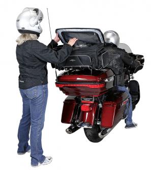 Photo of Traveler on red Harley Davidson trunk, woman behind motorcycle, man on motorcycle